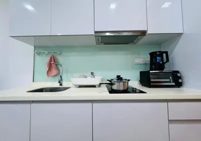 a kitchen with white cabinets and a sink and a stove at Bintang Suites Kuala Lumpur City Centre in Kuala Lumpur