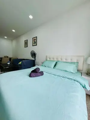 a large white bed with a purple pillow on it at Bintang Suites Kuala Lumpur City Centre in Kuala Lumpur