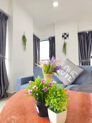 a living room with a table with flowers on it at Arte Plus by Stay Relax in Kuala Lumpur