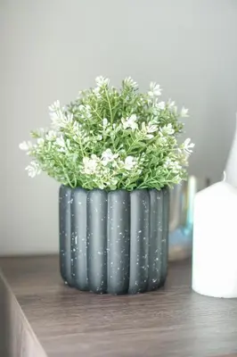 a black vase with white flowers on a table at Datum Jelatek Residence by Airhost in Kuala Lumpur