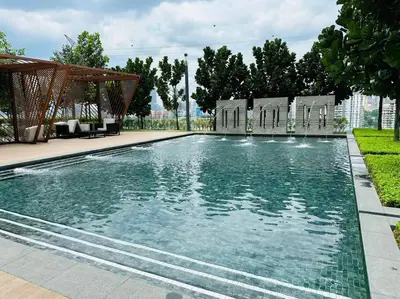 a swimming pool with chairs and trees in the background at M Vertica KL City 3B2B 8 Pax [Wi-Fi, 2 Carparks] in Kuala Lumpur