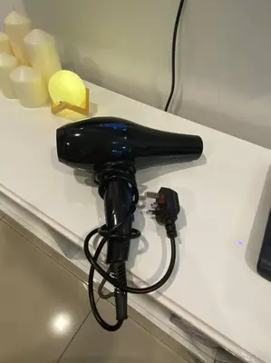 a black hairdryer sitting on a white table at CozyVista Setapak Central Mall 10Pax 3BR 2CarPark in Kuala Lumpur