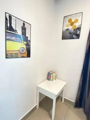 a white table in a room with two pictures on the wall at CozyVista Setapak Central Mall 10Pax 3BR 2CarPark in Kuala Lumpur
