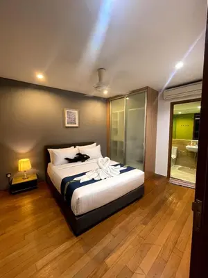 a bedroom with a bed with a cat laying on it at Vortex Suites KLCC 10 Pax -3 Bedroom Apartment in Kuala Lumpur