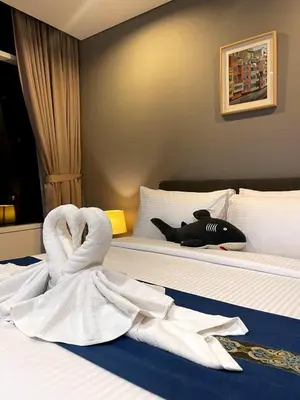 a bed with a white towel laying on it at Vortex Suites KLCC 10 Pax -3 Bedroom Apartment in Kuala Lumpur