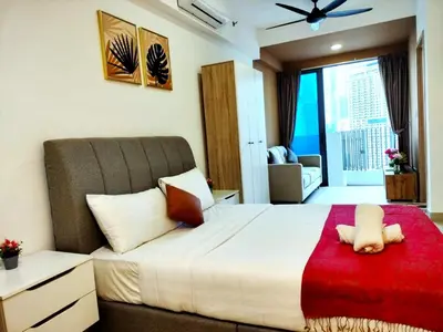 a bedroom with a large bed with a red blanket at Luxe Suites Home KLCC in Kuala Lumpur