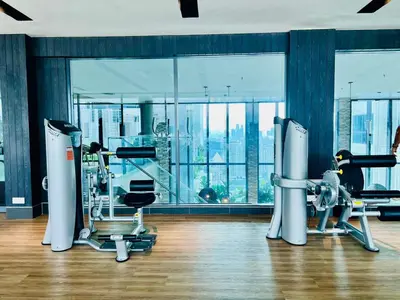 a gym with cardio equipment and a woman in the background at The Luxe Suites Infinitum KLCC in Kuala Lumpur