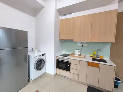 a kitchen with a washing machine and a washer at The Luxe Suites Infinitum KLCC in Kuala Lumpur