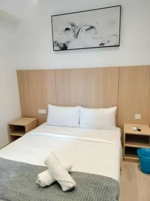 a bedroom with a large bed with white sheets at The Luxe Suites Infinitum KLCC in Kuala Lumpur