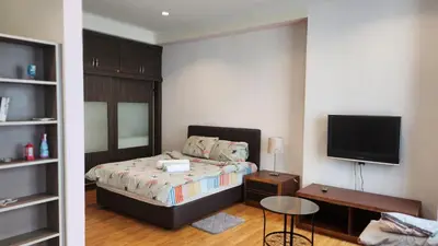 a bedroom with a bed and a flat screen tv at Parkview MALIKA KLCC in Kuala Lumpur