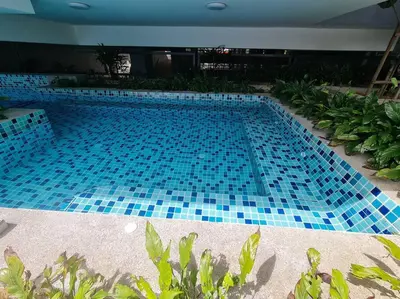 a large swimming pool with blue tiles on it at Tiny Studio Suite Near Gleneagles 10 mins to KLCC in Kuala Lumpur