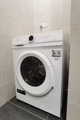 a washing machine in a room with a wall at Modern Comfy Studio Permaisuri 2 Carpark WIFI in Kuala Lumpur