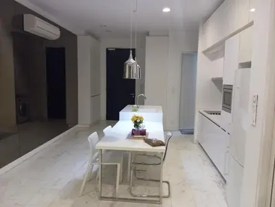 a white kitchen with a white table and chairs at Platinum suites klcc by Fifty One in Kuala Lumpur