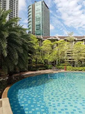 a large swimming pool with palm trees and buildings at Townhouse in KLCC Vicinity in Kuala Lumpur