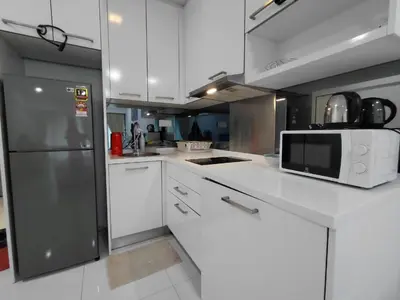 a kitchen with white cabinets and a stainless steel refrigerator at KLCC Summer Suite#3, Monorail, 4Pax in Kuala Lumpur