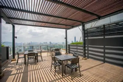 a patio with tables and chairs on a balcony at Neu Suite Ampang, LRT Jelatek, Gleneagles Hospital in Kuala Lumpur