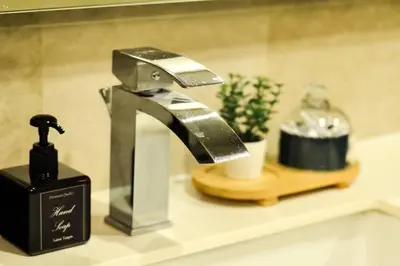 a bathroom sink with a faucet and a bottle of soap at KL Dorsett Damas Urban Garden Suite-F-Parking, Self C-In in Kuala Lumpur