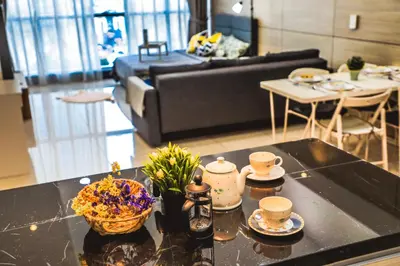 a living room with a table with cups and flowers on it at M CITY Near KLCC KPJ Puteri Specialist Hospital in Kuala Lumpur