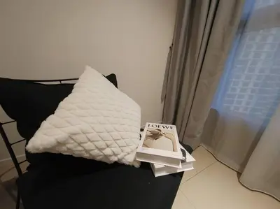 a book sitting on a couch with a pillow at Arcoris Mont Kiara 18# Sunway 163 Mall# 1 Mont Kiara # 2 BR with Balcony 2-4 Pax in Kuala Lumpur