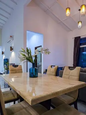 a dining room table with a vase of flowers on it at KL Secret Karaoke Private Pool Villa in Ampang