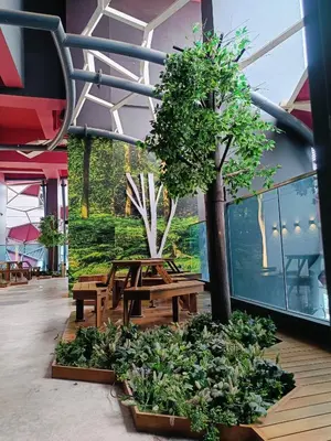 a table and bench in a building with a tree at Arte Plus by Stay Relax in Kuala Lumpur
