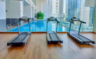 a gym with a swimming pool in a building at Lila House One Bukit Ceylon in Kuala Lumpur