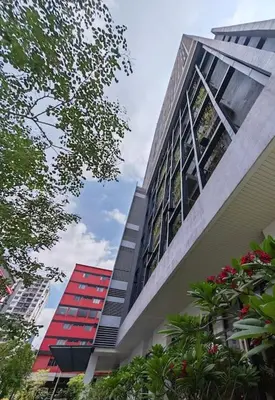 a tall building with two red windows and trees at Chambers A Studio Flat, KLCC & KL Tower view, City in Kuala Lumpur