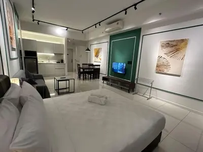 a bedroom with a white bed and a living room at Chambers A Studio Flat, KLCC & KL Tower view, City in Kuala Lumpur