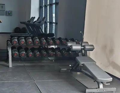 a gym with a bunch of dumbbells on a bench at Chambers A Studio Flat, KLCC & KL Tower view, City in Kuala Lumpur