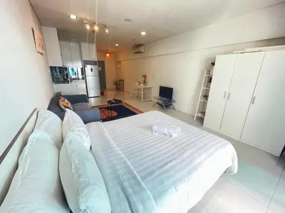 a bedroom with a bed and a living room at Mercu summer suites By Premium Charter in Kuala Lumpur