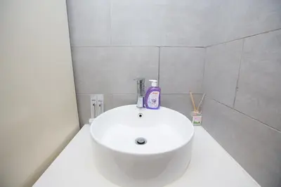 a bathroom sink with a bottle of soap on it at Arte Mont Kiara by MY TRIP & MY STAY in Kuala Lumpur