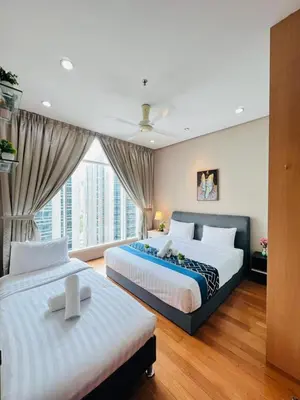 a bedroom with two beds and a large window at Soho Suites KLCC by Comfort Suites Kuala Lumpur in Kuala Lumpur