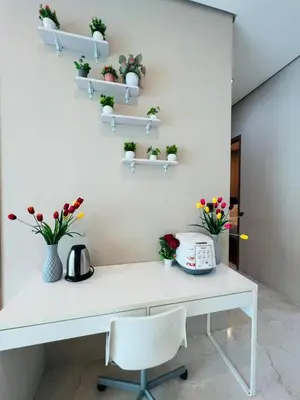 a white desk with potted plants on the wall at Soho Suites KLCC by Comfort Suites Kuala Lumpur in Kuala Lumpur