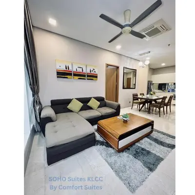 a living room with a couch and a table at Soho Suites KLCC by Comfort Suites Kuala Lumpur in Kuala Lumpur