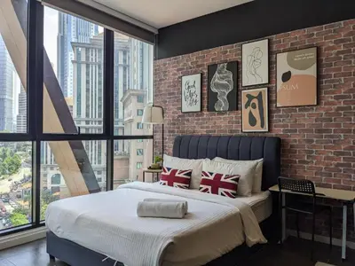 a bedroom with a large bed and a brick wall at Scarletz KLCC luxury suites by GC-Suites in Kuala Lumpur