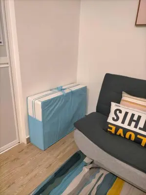 a living room with a couch and a blue bag at KL2-4pax studio nr KTM&Midvalley in Kuala Lumpur