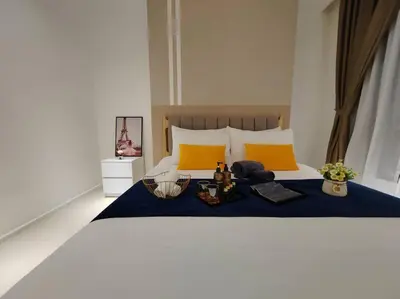 a bedroom with a bed with a blue blanket and yellow pillows at Arcoris Mont Kiara 2# Sunway 163# 2-Bedroom with balcony 2-4Pax in Kuala Lumpur