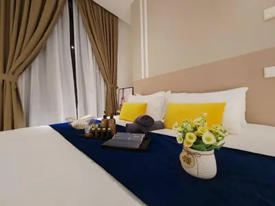 a hotel room with a bed with a blue blanket and flowers on it at Arcoris Mont Kiara 2# Sunway 163# 2-Bedroom with balcony 2-4Pax in Kuala Lumpur