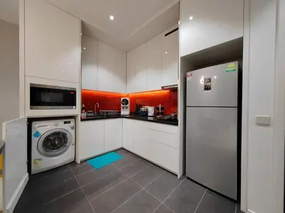 a kitchen with white cabinets and a washer and dryer at Arcoris Mont Kiara 19#Main Street# Walking Distance 1MK# 1BR 1-3Pax in Kuala Lumpur