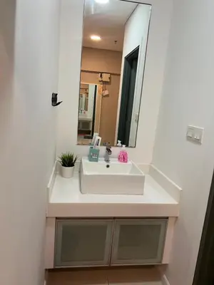 a bathroom with a white sink and a mirror at Summer Suites KLCC By Victorians in Kuala Lumpur