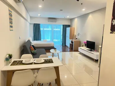 a living room with a couch and a table and chairs at Summer Suites KLCC By Victorians in Kuala Lumpur