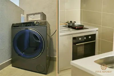 a kitchen with a washing machine and a stove at Trion One Suites Kuala Lumpur by Five Senses in Kuala Lumpur