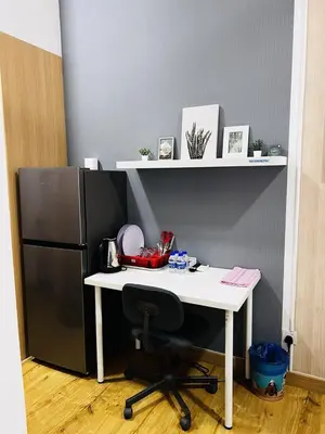 a desk with a black refrigerator and a white table at Voyage Bedroom, The Luxe Colony in Kuala Lumpur