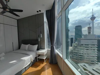 a bedroom with a bed and a large window at Sky Suites KLCC 3min walk to Twin Tower in Kuala Lumpur