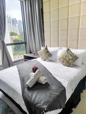 a bed with a towel on it with a window at Robertson Residences in Kuala Lumpur