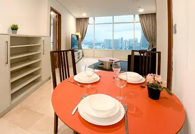 a dining room table with plates and wine glasses at Vortex KLCC by apartx in Kuala Lumpur