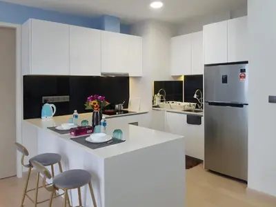 a kitchen with white cabinets and a refrigerator at KLCC Star Suites by BBA in Kuala Lumpur