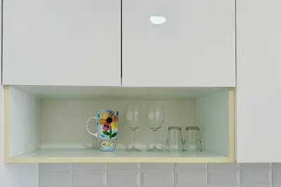 a shelf with two wine glasses and a mug at Continew by Xuan and Partner near KLCC and Bukit Bintang in Kuala Lumpur