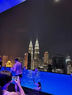 a group of people taking pictures of the city at night at The Platinum KLCC By Luxe Suites in Kuala Lumpur