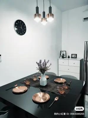 a dining room table with plates and a clock on the wall at Neu suites advance HomeStay klcc in Kuala Lumpur